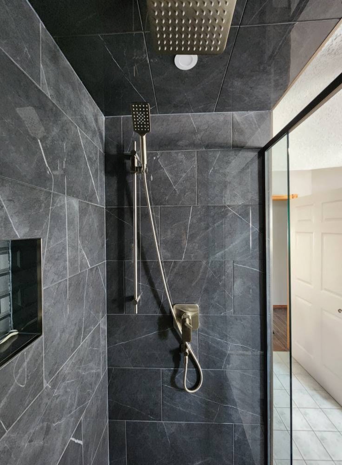 Modern tiled shower with rain head installed by Penberg Mechanical